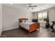 Calm bedroom featuring a ceiling fan, wood-look floors, a large window, and workout equipment at 26783 W Zachary Dr, Buckeye, AZ 85396