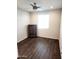 Bright bedroom features wood-look floors, ceiling fan, large window and a wooden dresser at 26783 W Zachary Dr, Buckeye, AZ 85396