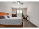 Comfortable bedroom featuring a soft, inviting bed, ceiling fan, and natural light from the window at 26783 W Zachary Dr, Buckeye, AZ 85396