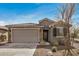 Charming single-story home with a two-car garage, stone accents, and desert landscaping at 26783 W Zachary Dr, Buckeye, AZ 85396