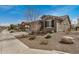 Charming single-story home with a two-car garage, stone accents, and desert landscaping at 26783 W Zachary Dr, Buckeye, AZ 85396