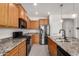 Well-lit kitchen featuring wooden cabinets, stainless steel appliances, and granite countertops at 26783 W Zachary Dr, Buckeye, AZ 85396