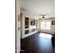 Living room featuring dark hardwood floors, a ceiling fan, and built-in shelving with a TV at 26783 W Zachary Dr, Buckeye, AZ 85396