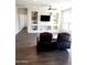 Living room featuring dark floors, a ceiling fan, a built-in TV, and plush seating at 26783 W Zachary Dr, Buckeye, AZ 85396