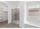 Well-lit bathroom featuring a glass shower, soaking tub, and ample natural light from a window at 36834 W La Paz St, Maricopa, AZ 85138