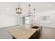 Spacious kitchen features a large island with sink, granite counters, and stainless-steel faucet at 36834 W La Paz St, Maricopa, AZ 85138