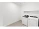 Well-lit laundry room with modern washer, dryer, and a storage shelf, offering practical convenience at 36834 W La Paz St, Maricopa, AZ 85138