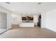 Bright, open living room and kitchen space featuring sleek floors and modern lighting fixtures at 36834 W La Paz St, Maricopa, AZ 85138