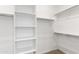 Bright walk-in closet with built-in white shelves and chrome rods for neatly organized storage space at 36834 W La Paz St, Maricopa, AZ 85138