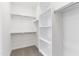 Well-lit walk-in closet featuring custom white shelving and chrome rods for organized storage solutions at 36834 W La Paz St, Maricopa, AZ 85138