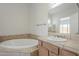 Bathroom with a tiled soaking tub, sink, and neutral countertops at 3948 W Salter Dr, Glendale, AZ 85308