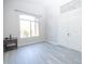 Well-lit bedroom with gray wood floors, a large window, and closet doors at 8031 N 108Th Dr, Peoria, AZ 85345