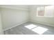 A well-lit bedroom with a window and modern gray flooring at 8031 N 108Th Dr, Peoria, AZ 85345