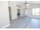 Bright and open living room with gray wood floors, a ceiling fan, and natural light at 8031 N 108Th Dr, Peoria, AZ 85345