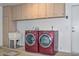 Well-equipped laundry room with side-by-side washer and dryer, utility sink, and overhead storage at 8390 W Oraibi Dr, Peoria, AZ 85382