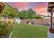 Backyard view at sunset with grassy area and shed at 16209 W Davis Rd, Surprise, AZ 85374