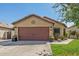 House exterior featuring a brown garage door and neat landscaping at 16209 W Davis Rd, Surprise, AZ 85374