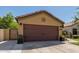 House exterior with a brown garage door and manicured landscaping at 16209 W Davis Rd, Surprise, AZ 85374