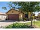 House exterior with a brown garage door and a tree in the front yard at 16209 W Davis Rd, Surprise, AZ 85374