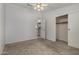 This bright bedroom features neutral walls, a ceiling fan, and a large closet for optimal storage at 215 N Power Rd # 361, Mesa, AZ 85205