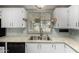 Bright kitchen featuring ample counter space, white cabinets, and modern stainless steel faucet at 215 N Power Rd # 361, Mesa, AZ 85205