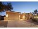 Tan stucco house with a two-car garage and desert landscaping at 12866 S 183Rd Ave, Goodyear, AZ 85338