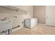 Laundry room with sink, shelving, and chest freezer at 21438 S 194Th St, Queen Creek, AZ 85142