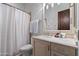 Well-lit bathroom featuring a vanity, decorative mirror, and shower with a patterned curtain at 6322 E Turquoise Ave, Paradise Valley, AZ 85253