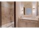 Elegant bathroom featuring tiled shower and vanity with decorative mirror and sconces at 6322 E Turquoise Ave, Paradise Valley, AZ 85253