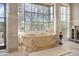 An elegant bathtub in a luxurious bathroom with large windows at 6322 E Turquoise Ave, Paradise Valley, AZ 85253