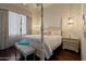 A beautiful bedroom features a four-poster bed, a bench, and hardwood floors at 6322 E Turquoise Ave, Paradise Valley, AZ 85253