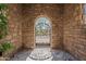 Stone courtyard with iron gate leading to lush landscaping and outdoor living spaces at 6322 E Turquoise Ave, Paradise Valley, AZ 85253