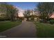 Expansive brick driveway leading to a beautiful home with mature trees and lush landscaping at 6322 E Turquoise Ave, Paradise Valley, AZ 85253