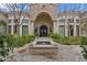 Charming home entrance with arched doorway, mature landscaping and a water feature for curb appeal at 6322 E Turquoise Ave, Paradise Valley, AZ 85253
