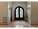 A welcoming foyer features arched wrought iron double doors, sconces, and tile flooring at 6322 E Turquoise Ave, Paradise Valley, AZ 85253