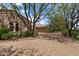 Home exterior featuring a stone facade, three-car garage, mature trees and lush landscaping at 6322 E Turquoise Ave, Paradise Valley, AZ 85253