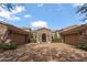 Home exterior featuring a stone facade, three-car garage, arched entryway, and lush landscaping at 6322 E Turquoise Ave, Paradise Valley, AZ 85253