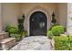 Inviting front entrance with custom iron doors, stone accents, and manicured landscaping at 6322 E Turquoise Ave, Paradise Valley, AZ 85253