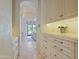 Bright hallway featuring stone floors, custom cabinetry, and an arched doorway leading to the kitchen at 6322 E Turquoise Ave, Paradise Valley, AZ 85253