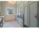 Bright laundry room with dual washer and dryer units, custom cabinets, and a window with natural light at 6322 E Turquoise Ave, Paradise Valley, AZ 85253