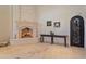 Elegant living room featuring a stone fireplace, travertine floors, and a decorative iron door at 6322 E Turquoise Ave, Paradise Valley, AZ 85253