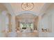 An elegant living room features high ceilings, decorative columns, a chandelier, and plenty of natural light at 6322 E Turquoise Ave, Paradise Valley, AZ 85253