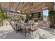 Inviting outdoor living area with a stone fireplace, built-in grill, and comfortable seating beneath a pergola at 6322 E Turquoise Ave, Paradise Valley, AZ 85253
