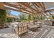 Relaxing outdoor living space featuring a pergola, outdoor kitchen, and comfortable seating surrounded by greenery at 6322 E Turquoise Ave, Paradise Valley, AZ 85253