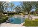 Inviting in-ground pool with stone waterfalls, surrounded by verdant hedges and a lush, landscaped backyard at 6322 E Turquoise Ave, Paradise Valley, AZ 85253
