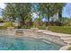 Close-up of the beautiful in-ground pool with its stone waterfalls, showcasing clear water and intricate tile work at 6322 E Turquoise Ave, Paradise Valley, AZ 85253