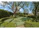 Private putting green surrounded by manicured hedges and mature trees, perfect for golf enthusiasts at 6322 E Turquoise Ave, Paradise Valley, AZ 85253