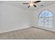 Bright bedroom with neutral carpet, ceiling fan, and an arched window at 2955 N Augustine --, Mesa, AZ 85207