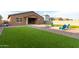 Backyard with artificial turf, fire pit, and blue chairs at 4969 W Beckham Way, San Tan Valley, AZ 85144