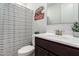 Clean bathroom with dark vanity, white sink, and striped shower curtain at 4969 W Beckham Way, San Tan Valley, AZ 85144